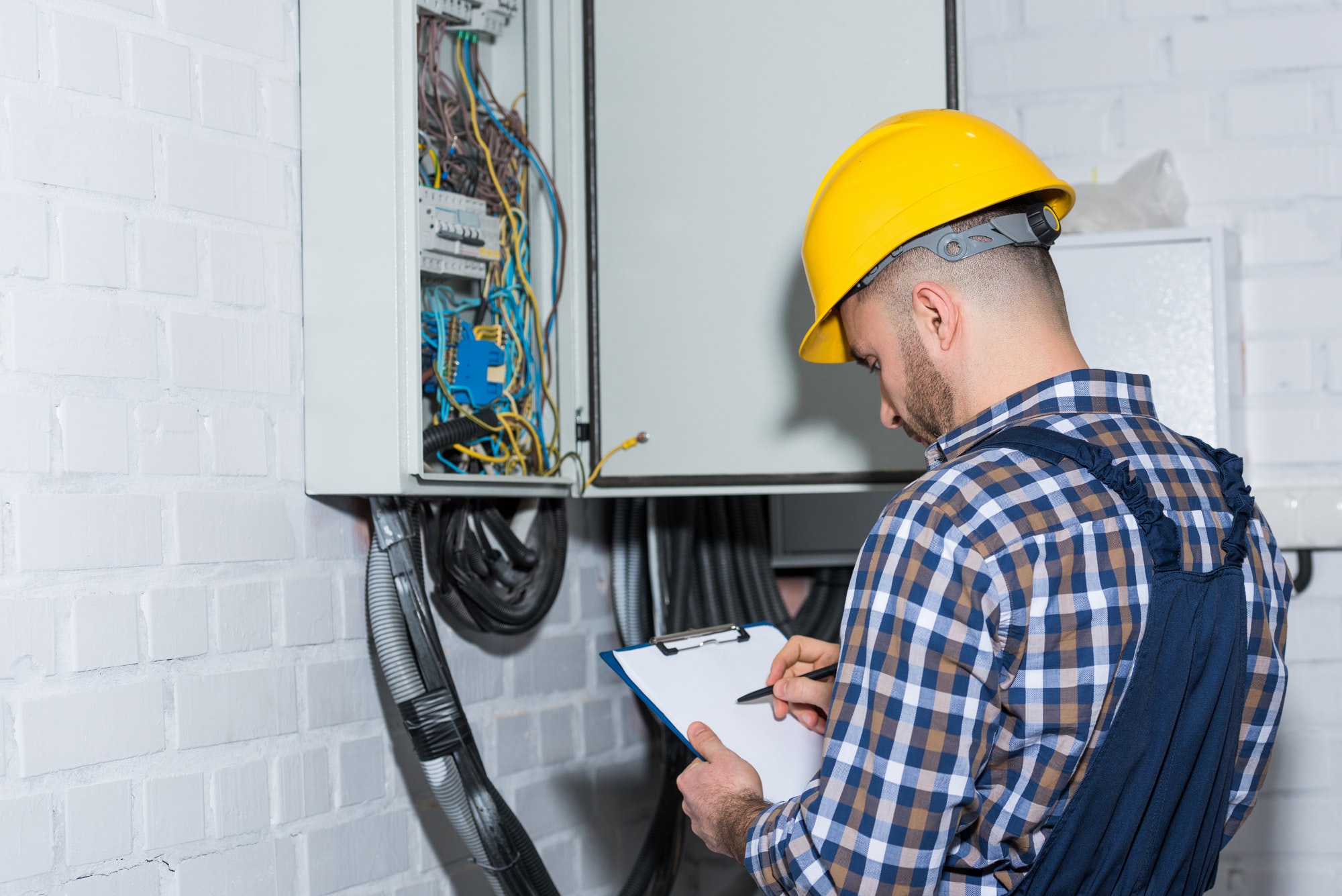 professional electrician inspecting wires in electrical Vérification Électrique Marseille